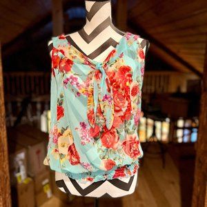 Beautiful sheer light sleeveless blouse with floral pattern on blue background